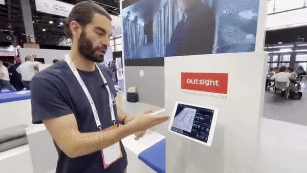 Outsight team member Erwan Le Roux demonstrates a LiDAR-powered interface on a touchscreen at a tech exhibition, showcasing real-time spatial analytics